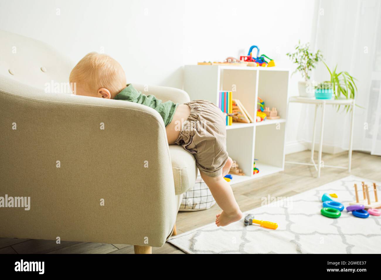 Cute Baby Climbing On Sofa At Home Stock Photo Alamy