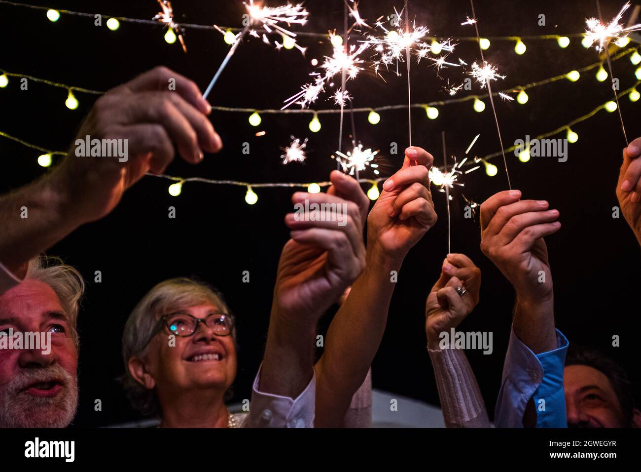 Low Angle View Of People Holding Illuminated Sparklers Stock Photo