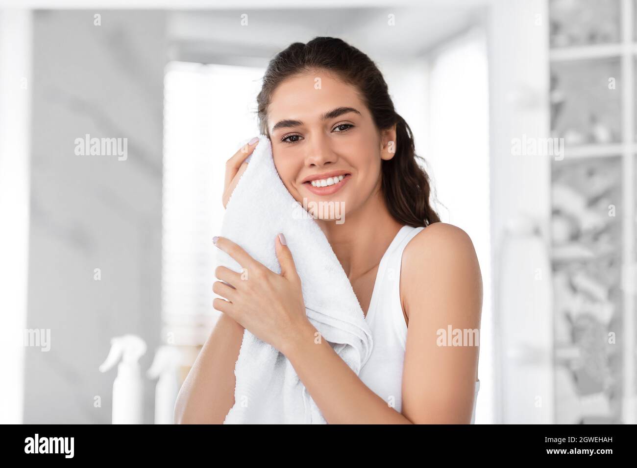 https://c8.alamy.com/comp/2GWEHAH/portrait-of-young-woman-drying-face-with-towel-smiling-to-camera-standing-after-shower-in-bathroom-at-home-morning-beauty-and-hygiene-routine-and-fac-2GWEHAH.jpg