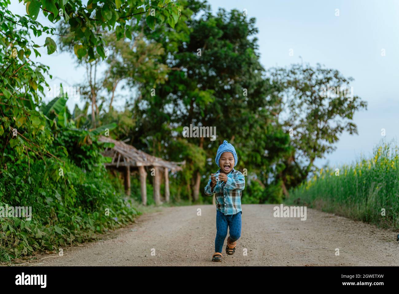 Portrait Of Happy Boy Walking On Country Road Stock Photo