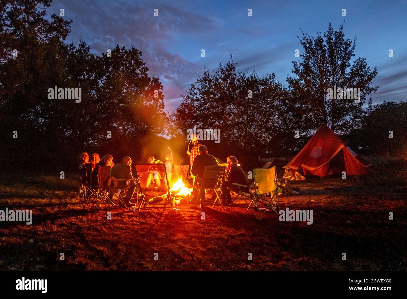 Hartfield, September 25th 2021: A group of friends enjoying a late summer, early evening campfire Stock Photo