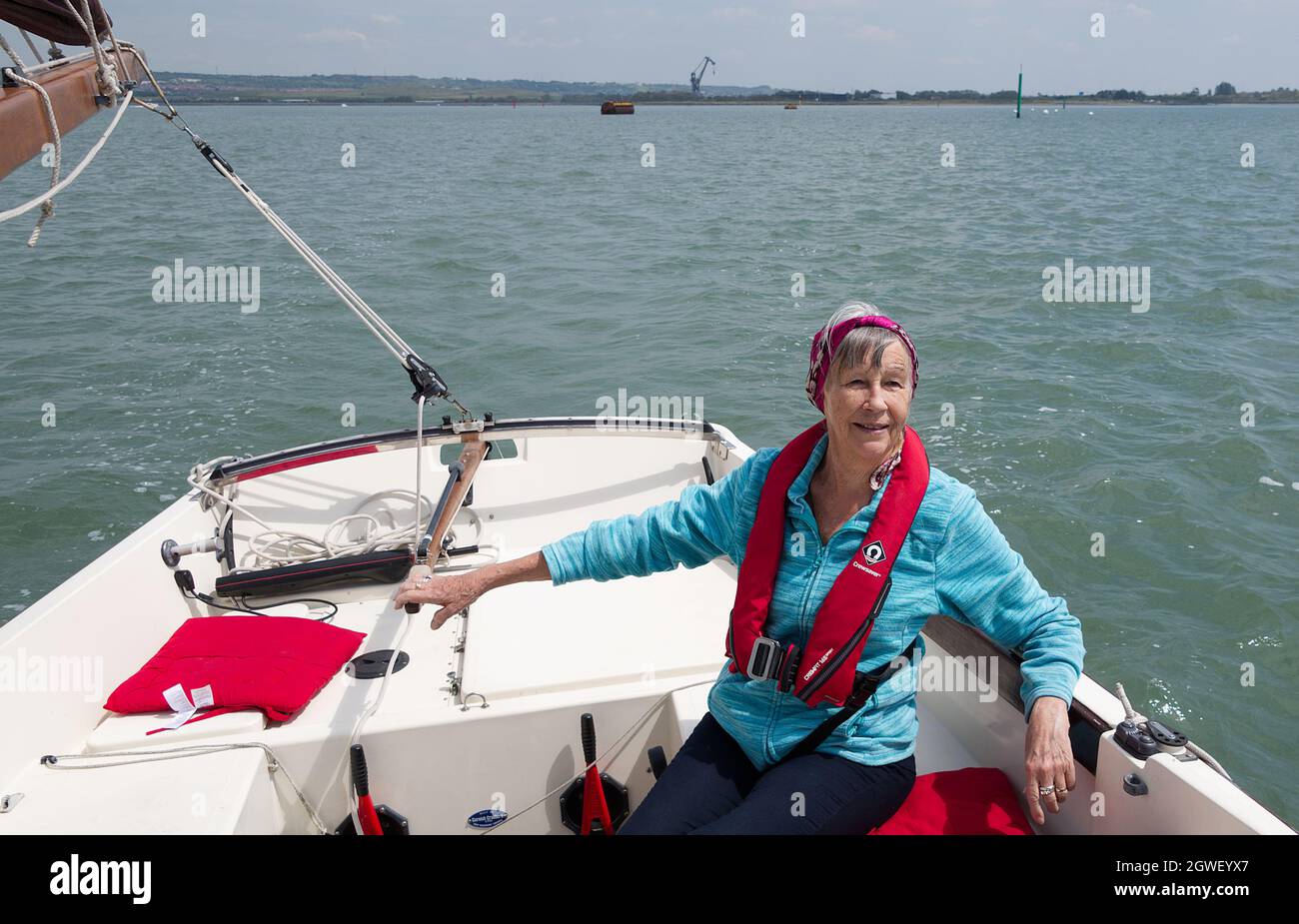 Mature woman at the helm of a Cornish Shrimper Stock Photo
