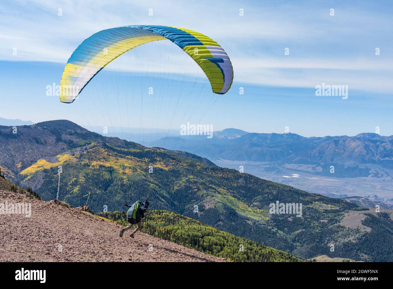 A paraglider pilot runs to launch his paraglider off the top of Monroe