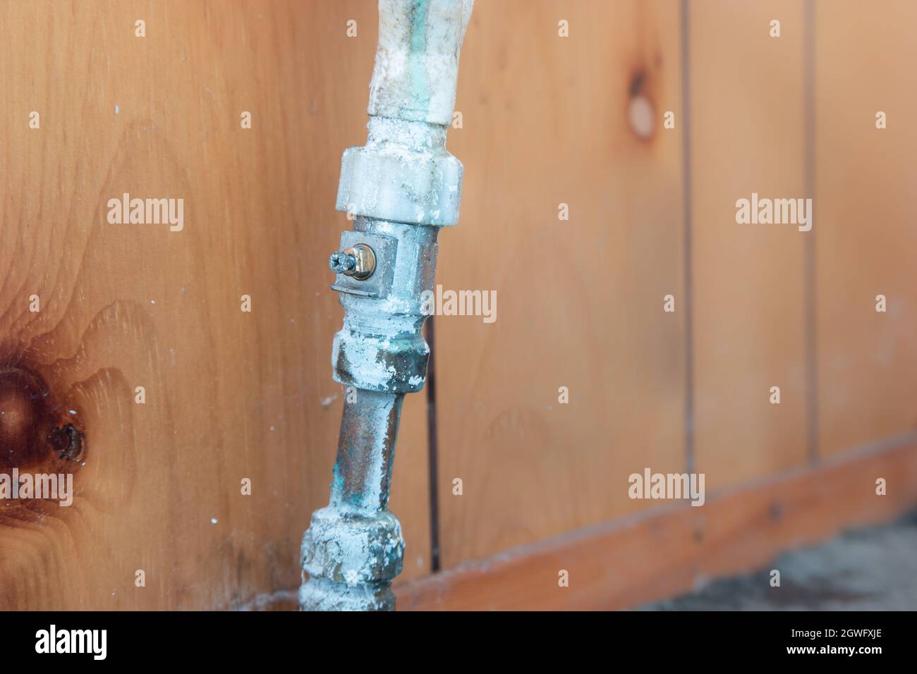 Old leaking pipe with broken isolation valve screw, compression tap fitting, showing water and limescale damage Stock Photo