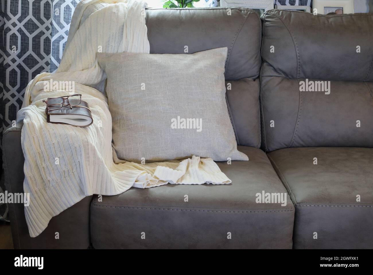 https://c8.alamy.com/comp/2GWFXK1/soft-knit-throw-blanket-over-the-arm-of-a-grey-couch-in-a-farmhouse-style-living-room-with-closed-book-and-reading-glasses-2GWFXK1.jpg