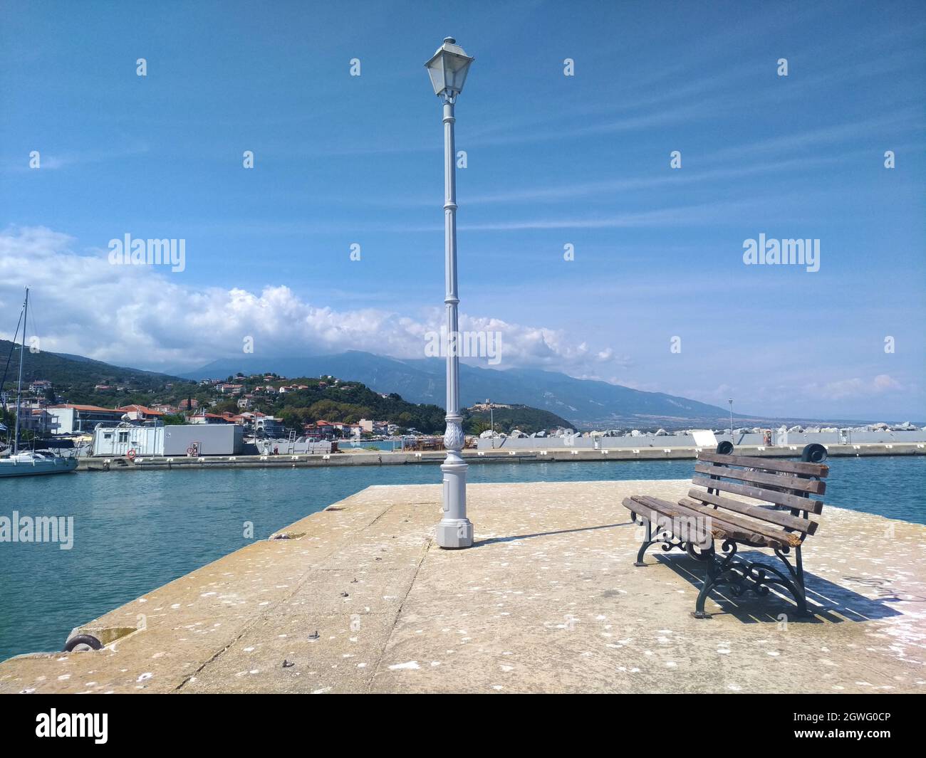 Single Bench In Port With The Sea In Background Stock Photo