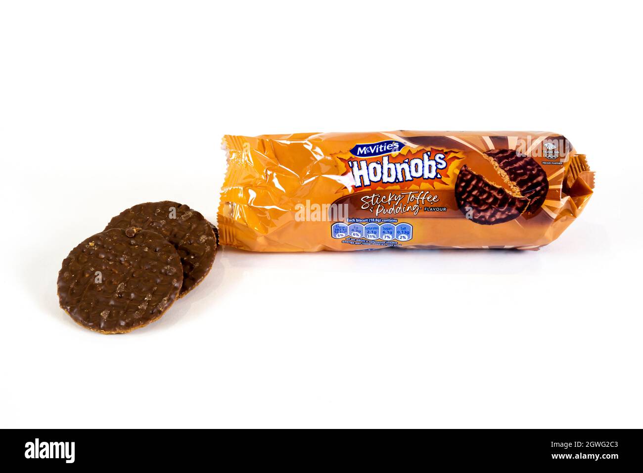 An opened packet of sticky toffee pudding flavour McVities Hobnobs biscuits with two biscuits next to the packet. Stock Photo