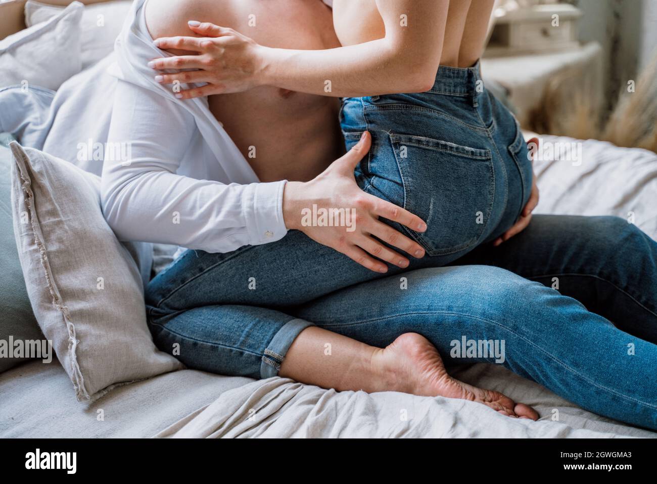 Midsection Of Couple Sitting On Bed At Home Stock Photo