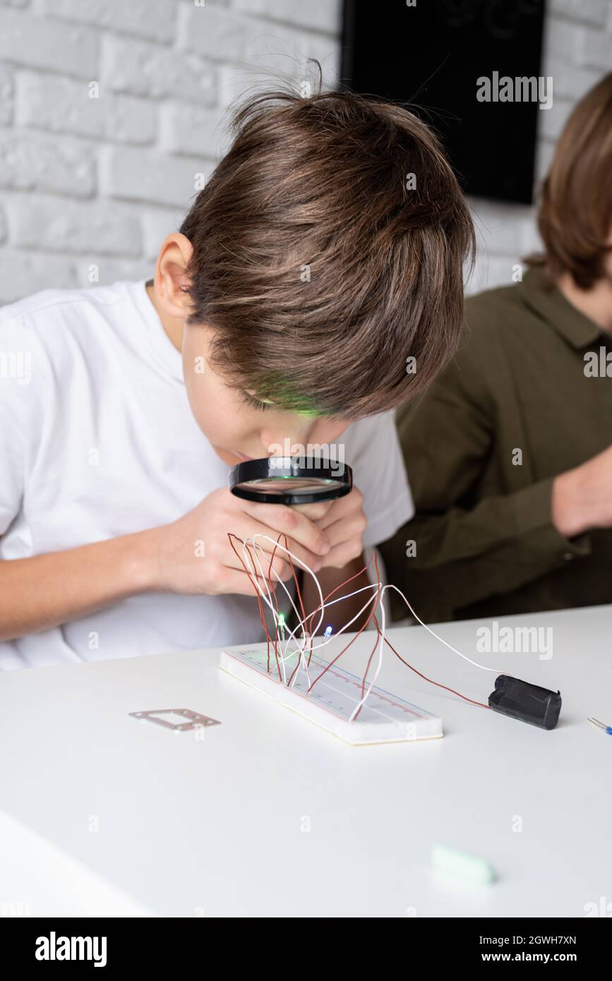 Boy Working With Led Lights On Experimental Board For Science Project