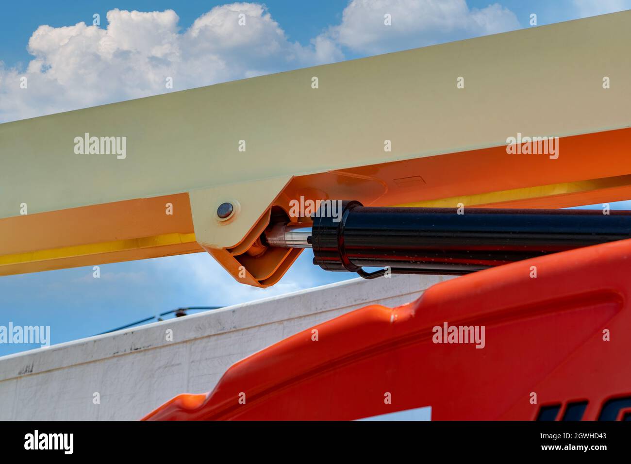 Closeup Hydraulic Of Boom Lift. Orange Articulated Boom Lift