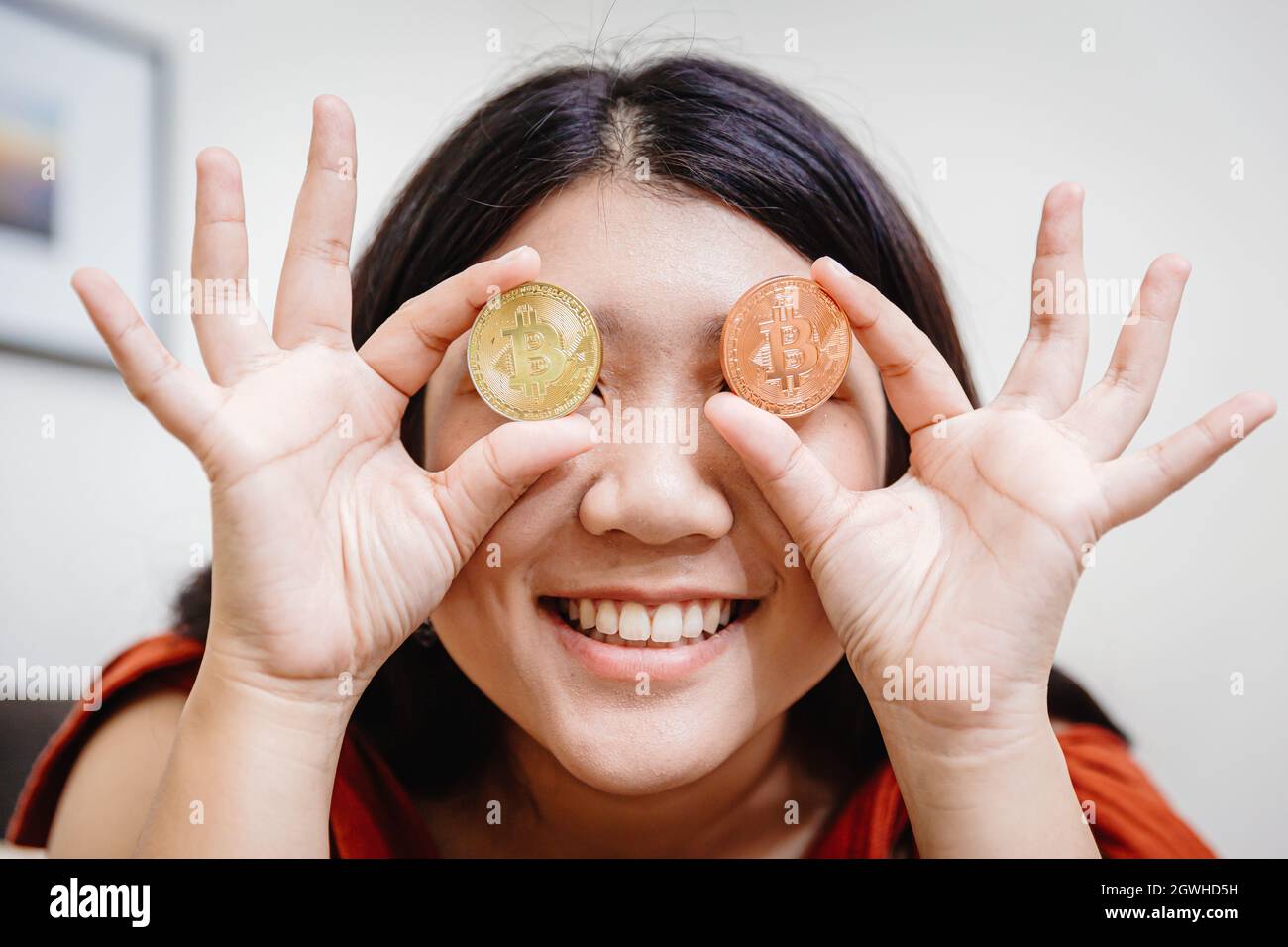 teen girl holding bitcoin at eyes for happy looking market vision to  trading cryptocurrency concept Stock Photo - Alamy