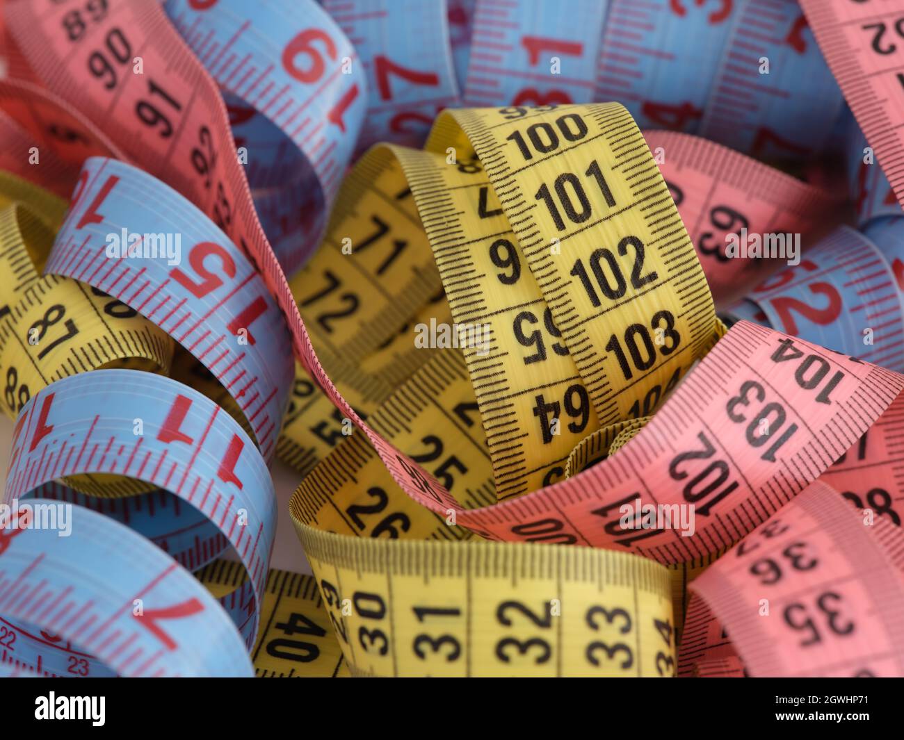 https://c8.alamy.com/comp/2GWHP71/a-lot-of-colorful-measuring-tape-in-a-pile-close-up-2GWHP71.jpg