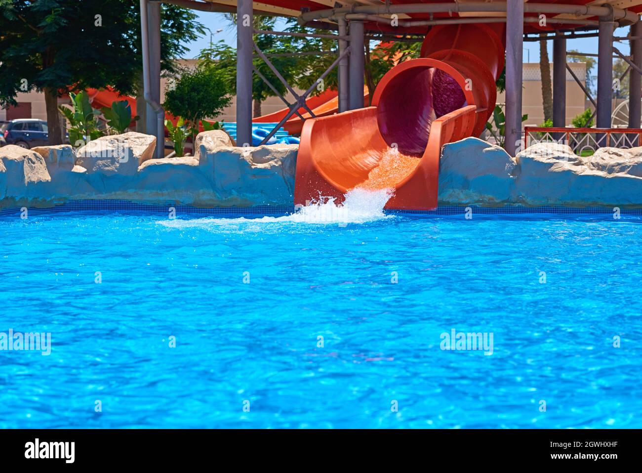 Red Water Park Slide And Swimming Pool. Aqua Park Background Stock