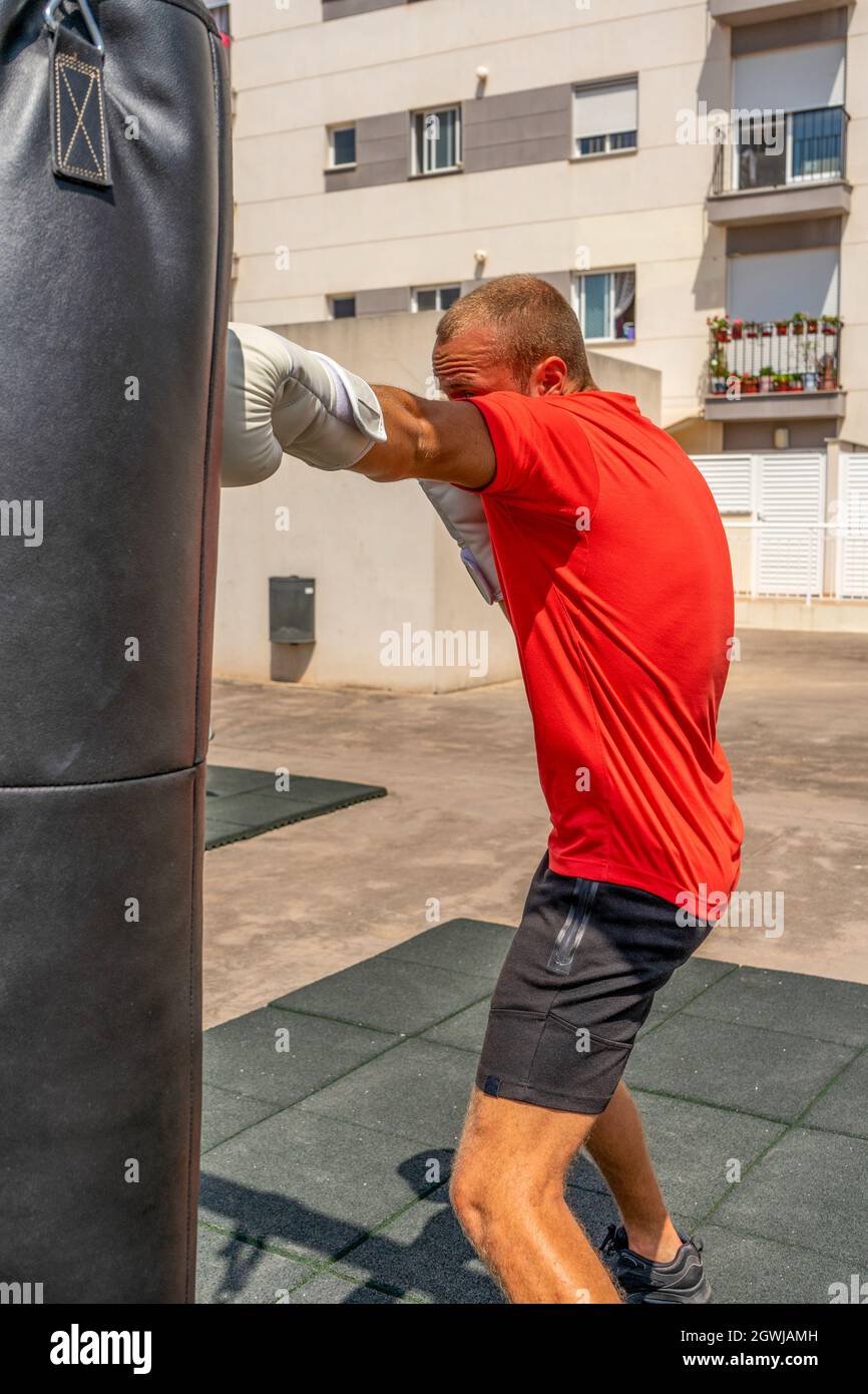 Joyful young man boxing in the street. Sports and health concept