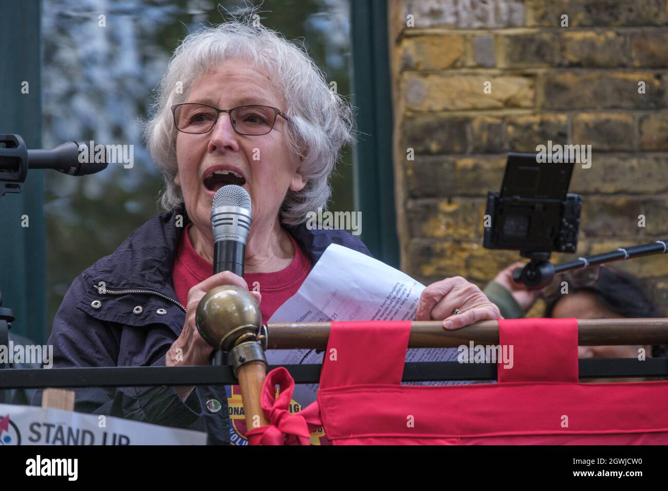 London, UK. 3rd Oct 2021. Marlene Sideaway of the International Brigade Memorial Trust talks about those who went to fight fascism in the Spanish Civil War at the rally on the 85th anniversary of the Battle of Cable St to remember the act of unity against the fascist threat when the Jewish and Irish communities of East London and their allies blocked the streets to prevent Oswald Mosley and his British Union of Fascists marching through. They marched from Dock St along Cable St to a rally next to the mural in St George's Gardens chaired by Jewish historian David Rosenberg and local Bengali act Stock Photo