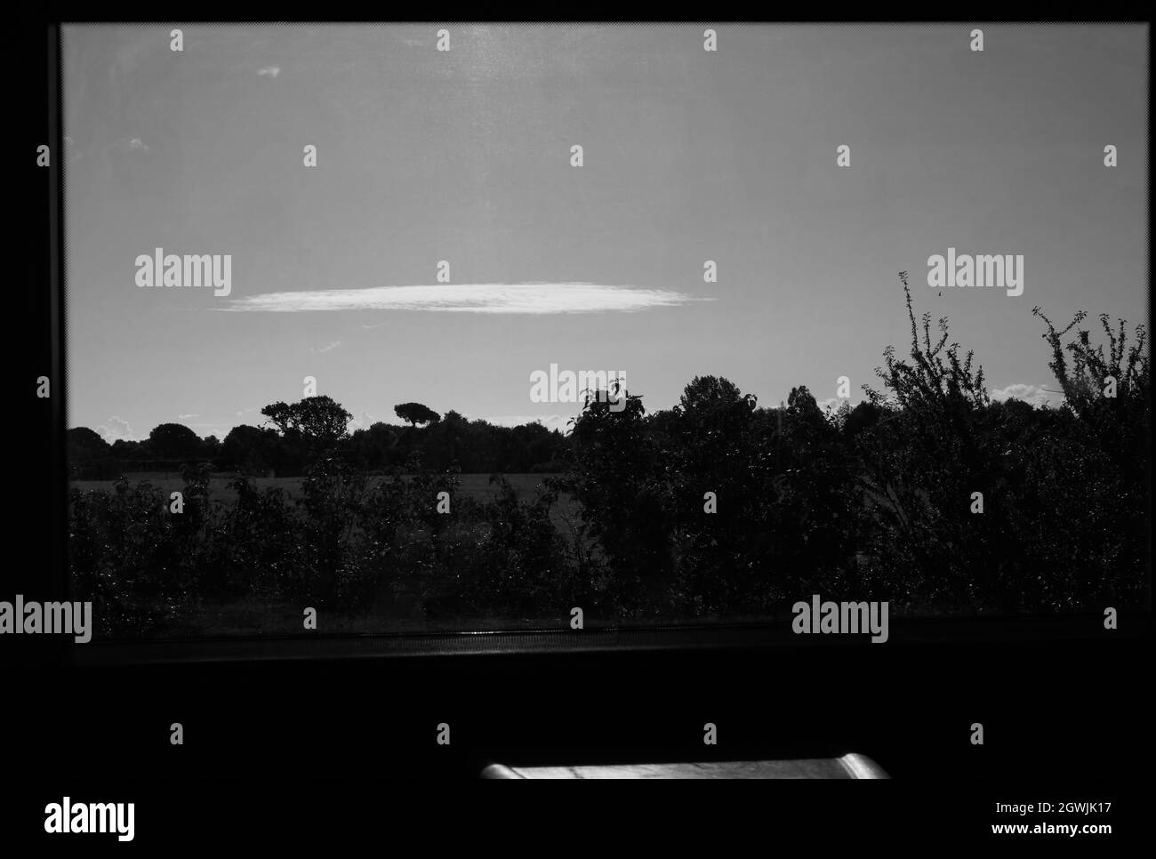 Black and white view of English countryside through a window of a train in the uk. Stock Photo