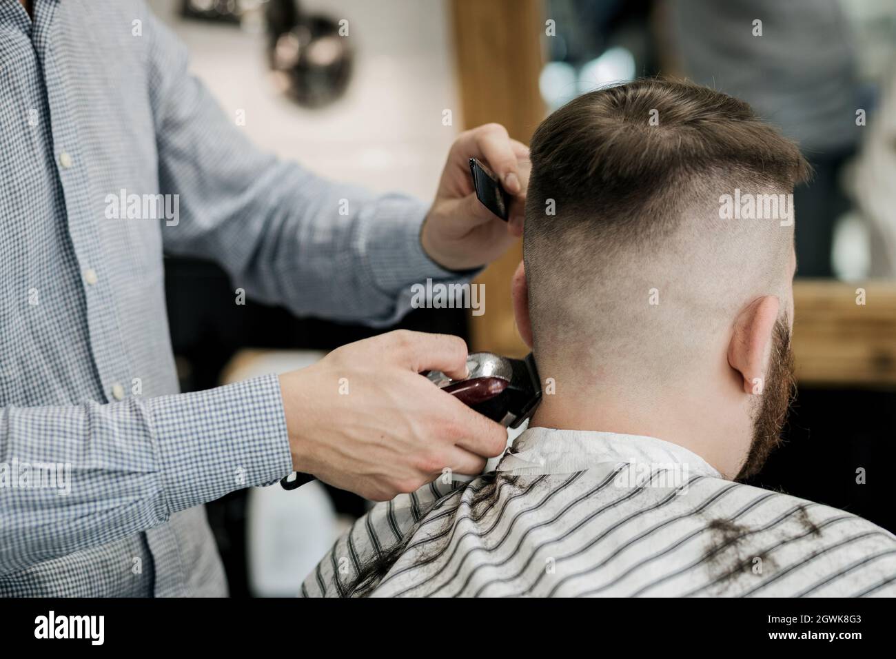 barber shaves the back of the client's head in the salon. haircut at