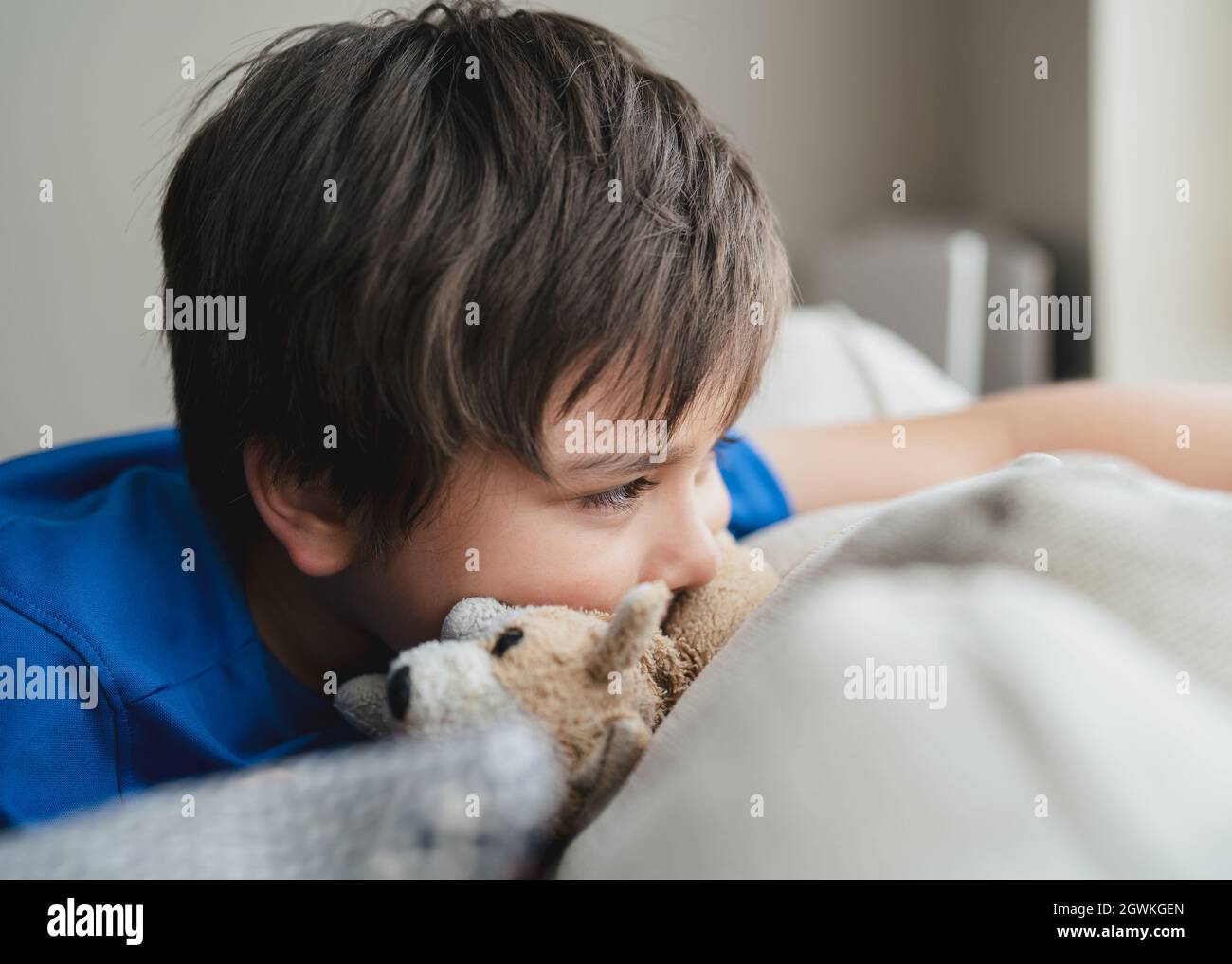 Portrait Of Boy Lying On Bed At Home Stock Photo