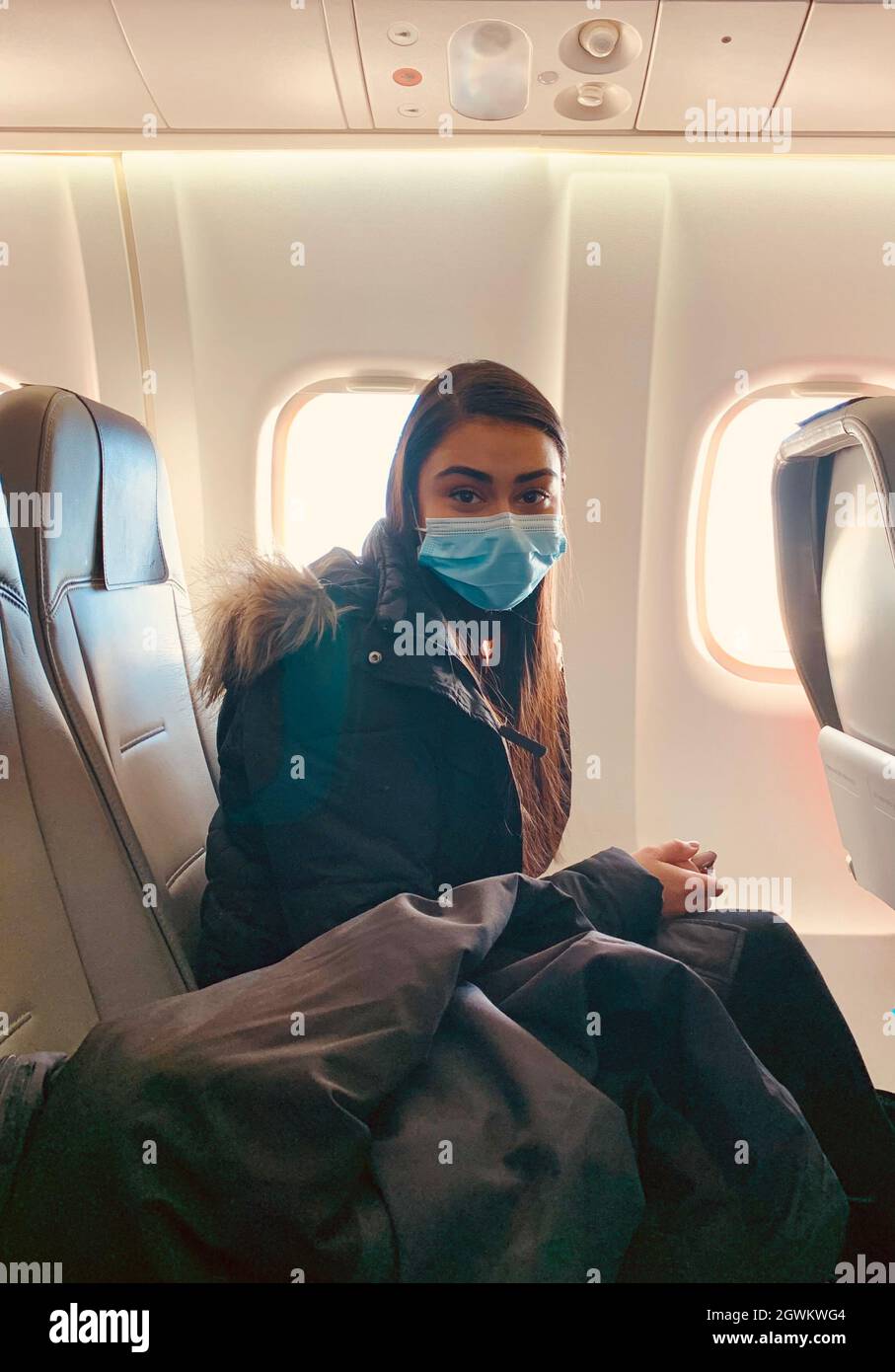 Person wearing surgical mask airplane hires stock photography and