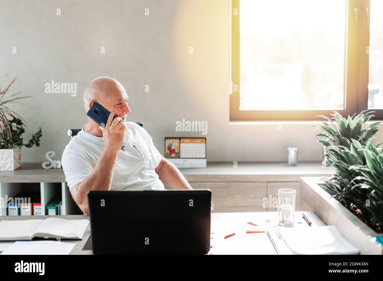 Middle aged business man talking on the phone in the office. Casual work wear. Business concept Stock Photo