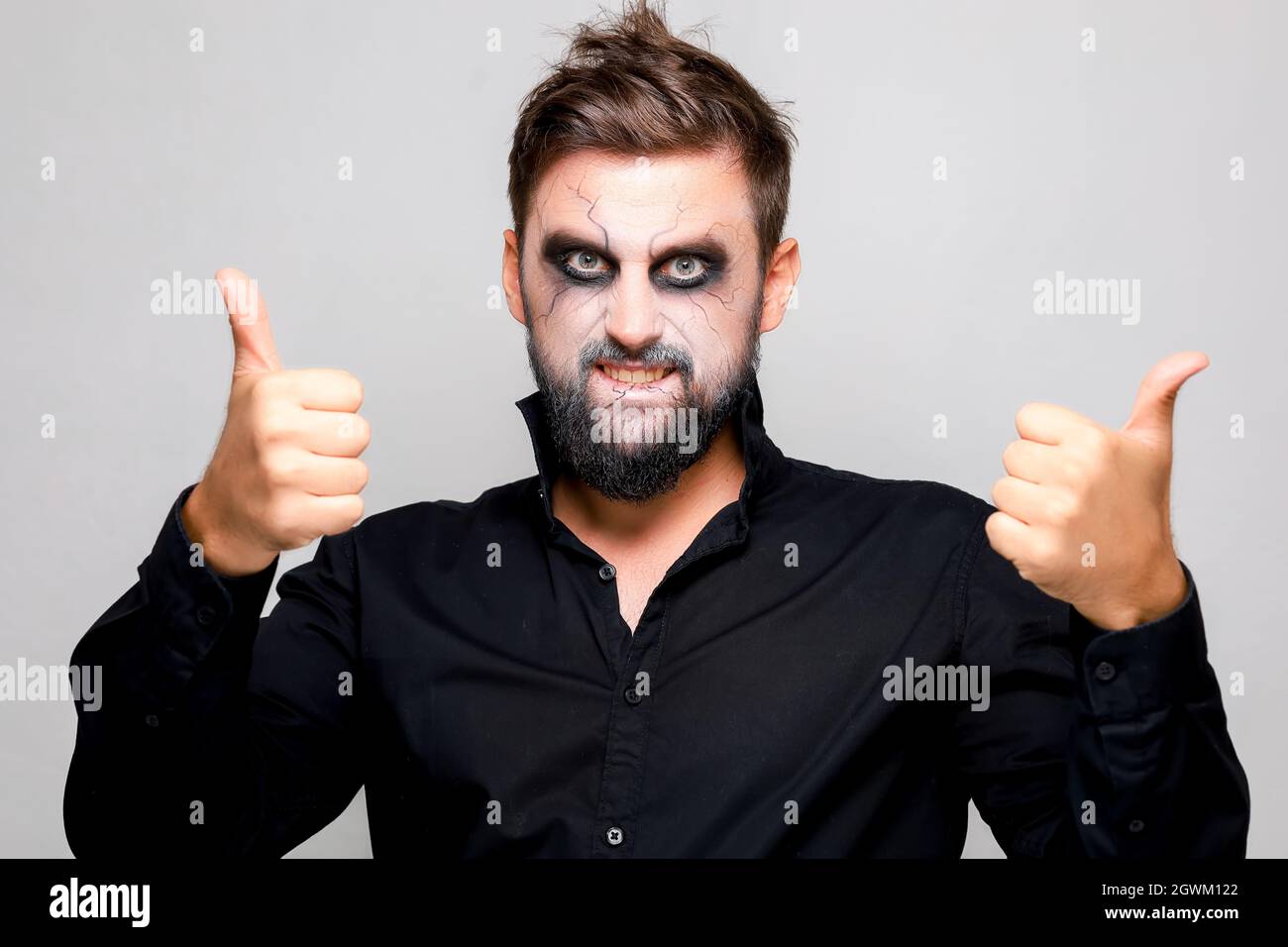 Bearded man with undead makeup gives a thumbs up Stock Photo