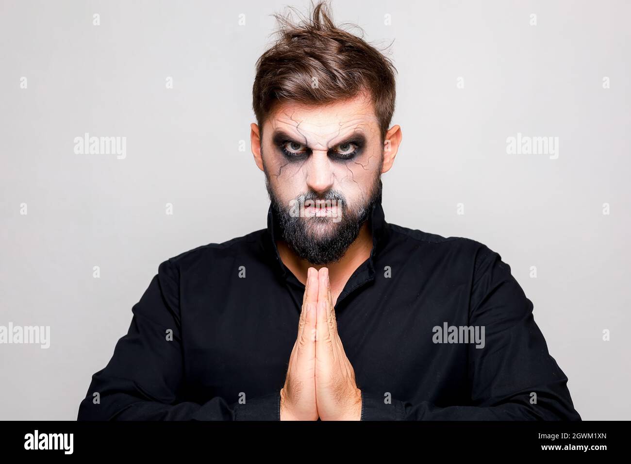 Scary undead-style makeup for Halloween on a bearded man who shows gestures  Stock Photo - Alamy