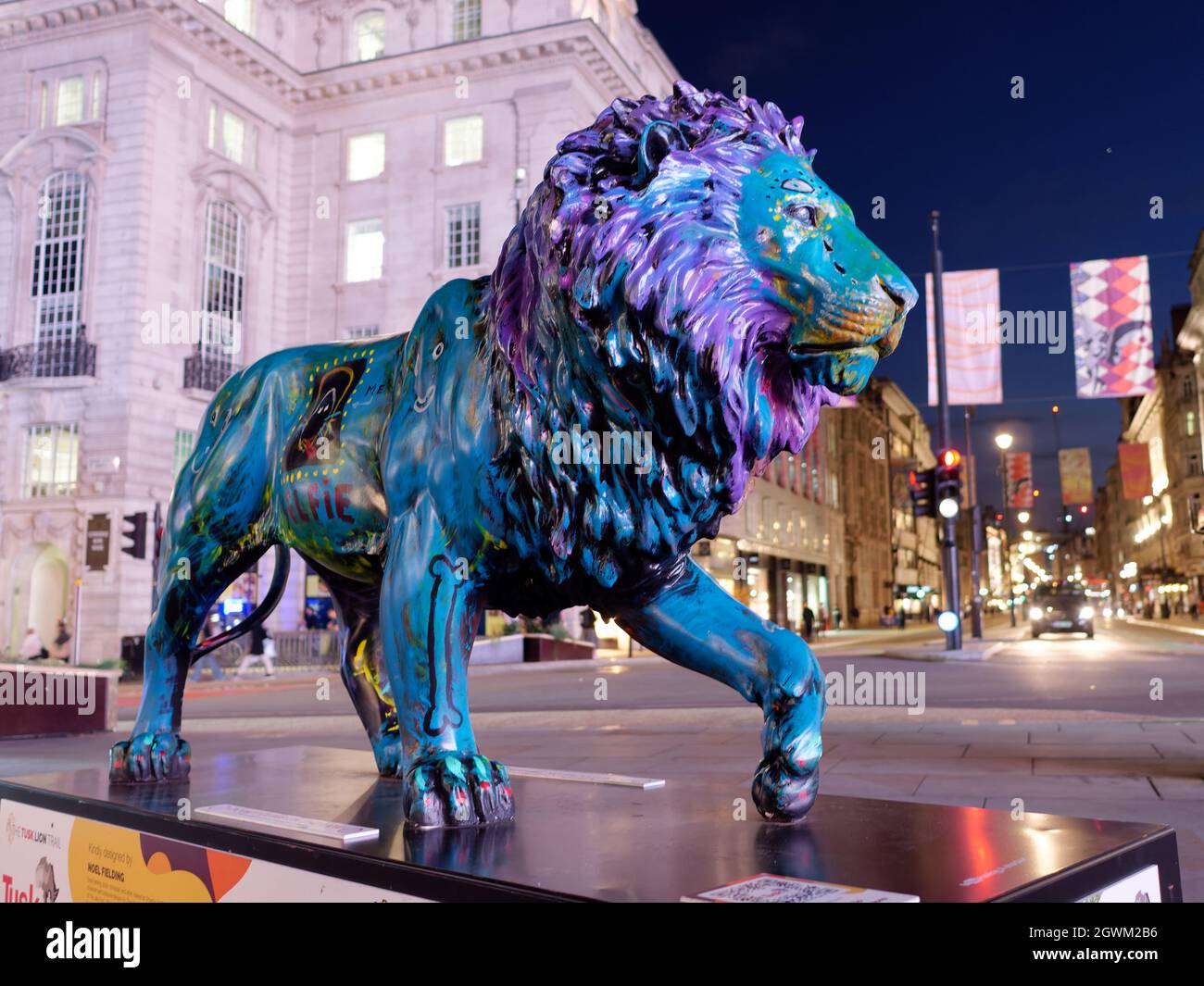 London, Greater London, England, September 21 2021: Tusk Lion Trail Lion statues at night in Piccadilly Circus, this statue is called A Hard Mane is G Stock Photo