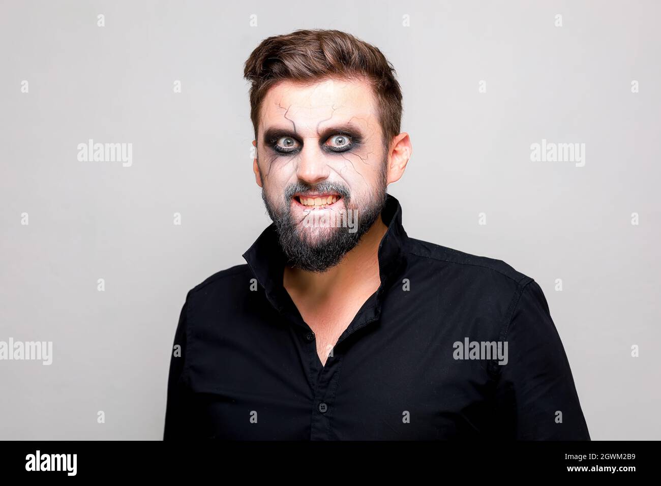 undead makeup for October 31 on a bearded man who shows teeth Stock ...