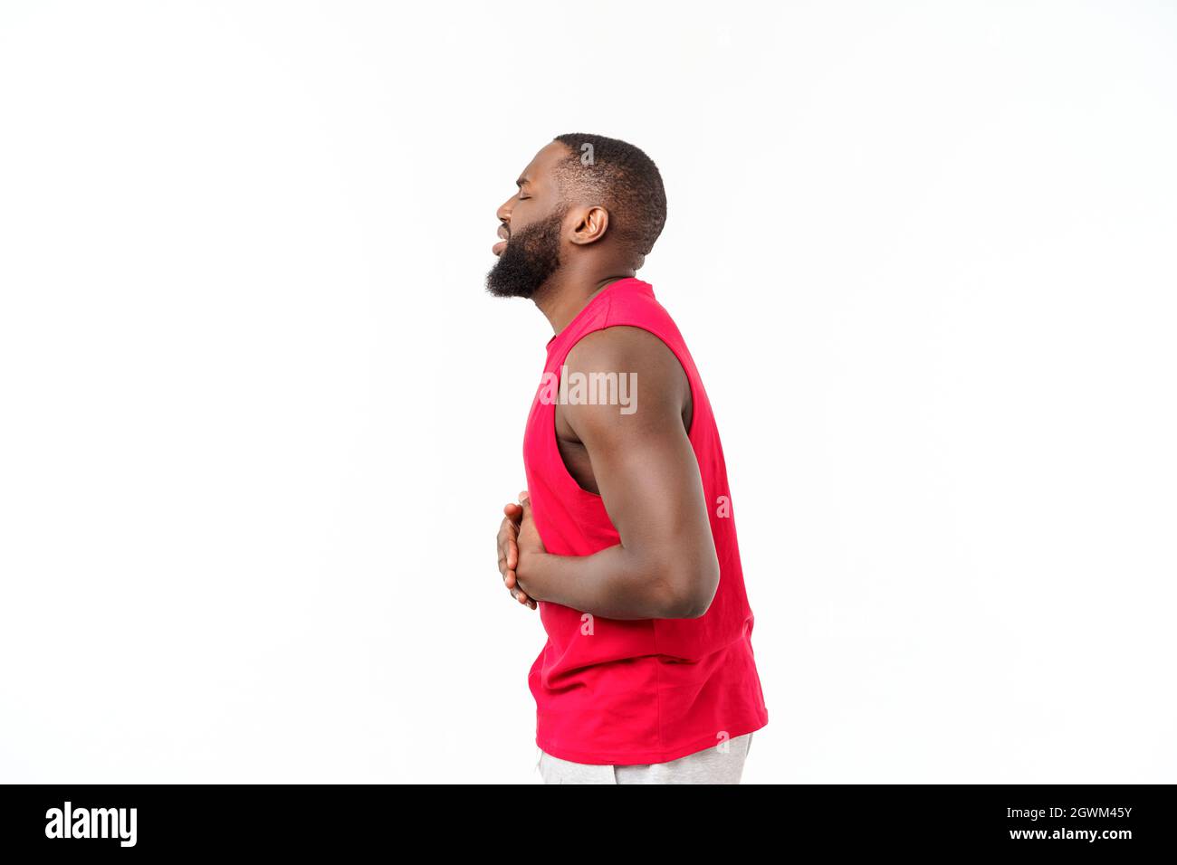 Young african american man over isolated background wearing sport wear with hand on stomach because nausea, painful disease feeling unwell. Stock Photo