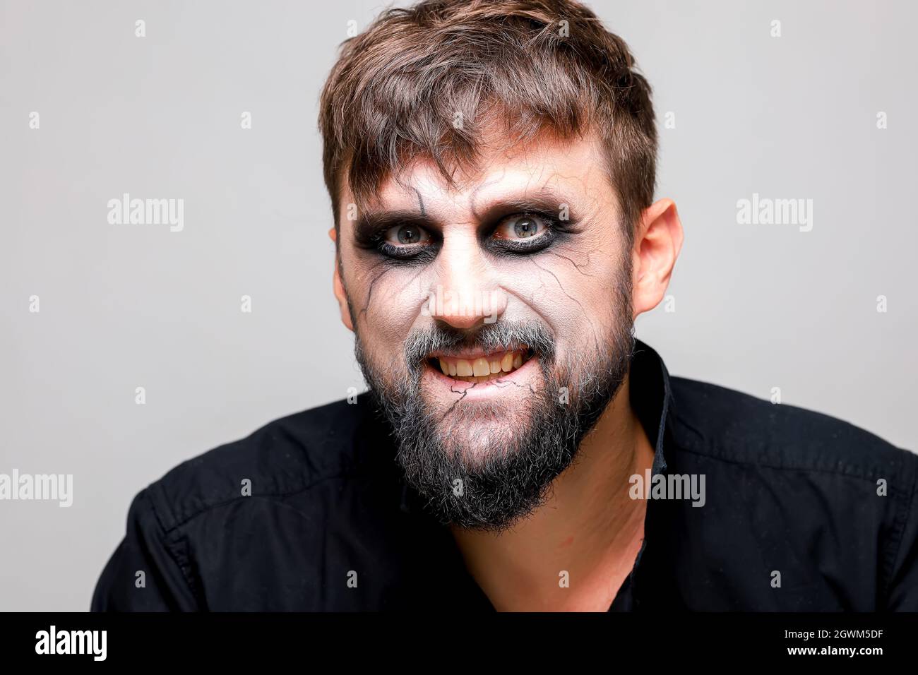 a man with undead-style makeup laughs and shows his teeth Stock Photo