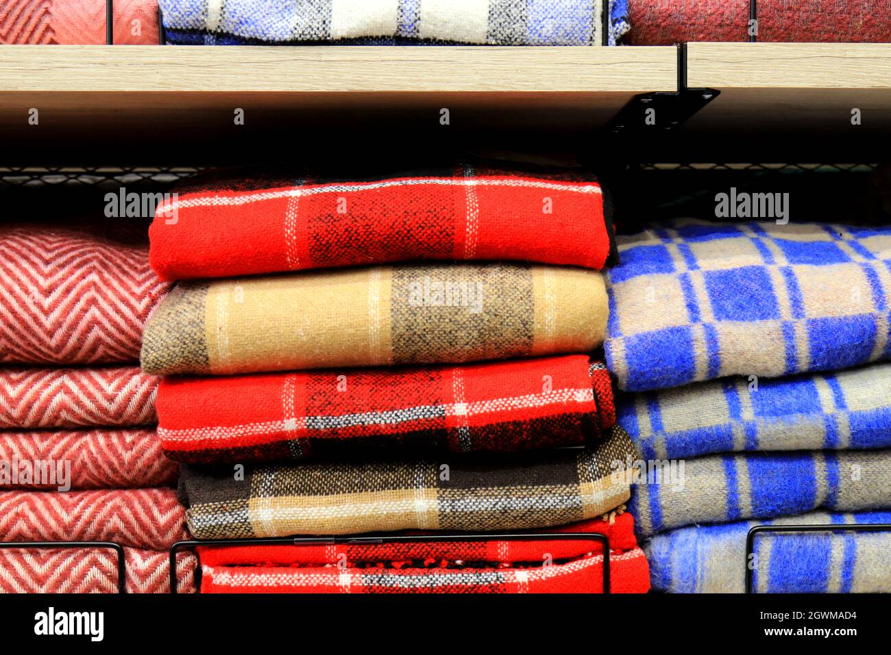 A stack of beautiful woolen blankets in red, blue, yellow, pink. A pile