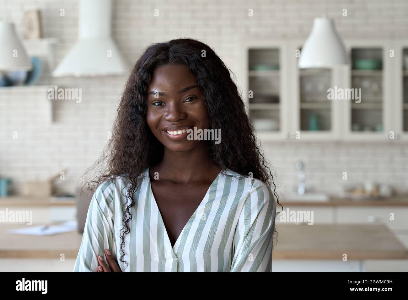 Headshot portrait of young black woman looking at camera indoors. Stock Photo