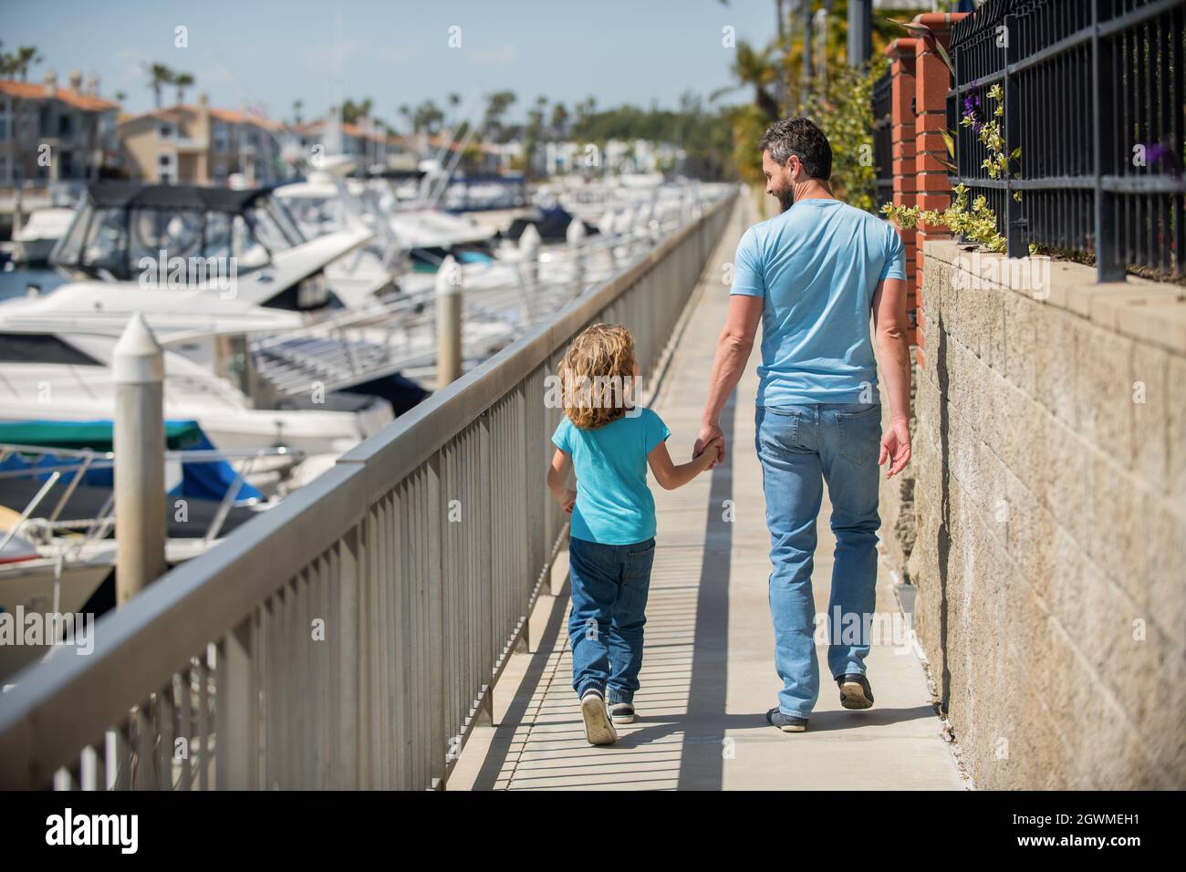 single dad leading small kid outside back view, family Stock Photo