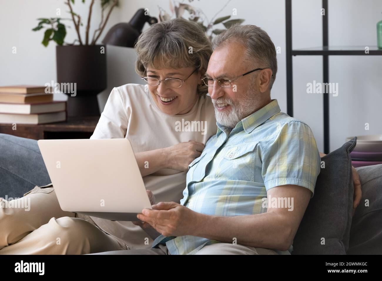 Happy bonding mature older family couple using computer. Stock Photo