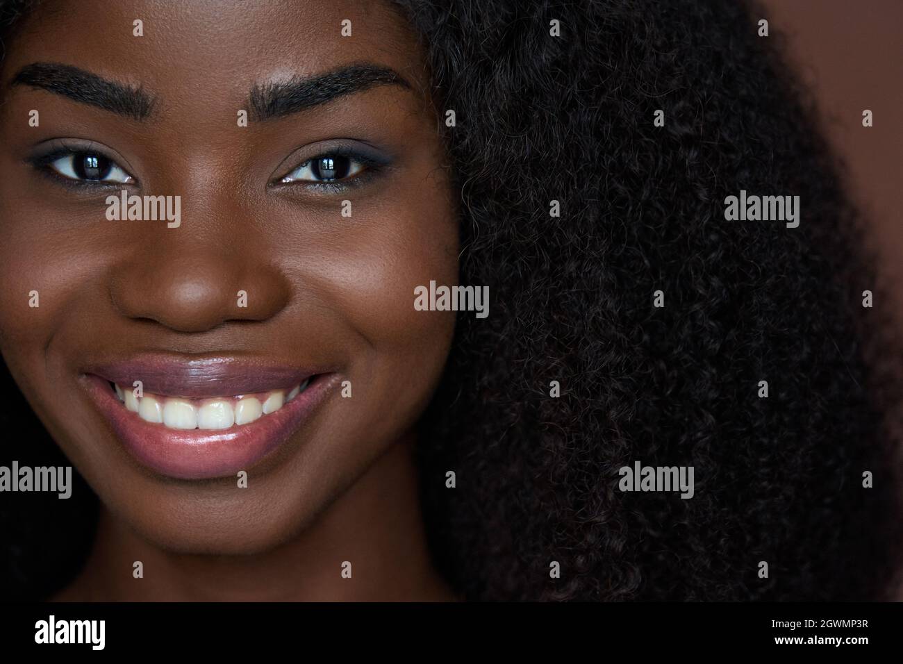 Beautiful young black girl looking at camera. Beauty concept. Closeup front. Stock Photo