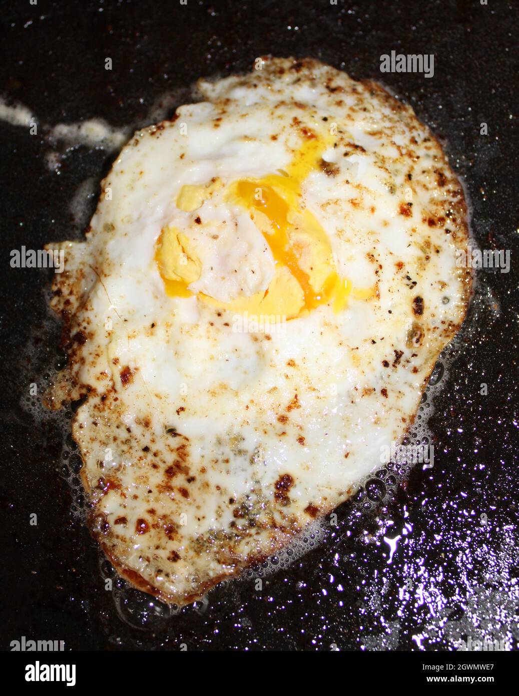 Fried egg cooking on a griddle Stock Photo Alamy