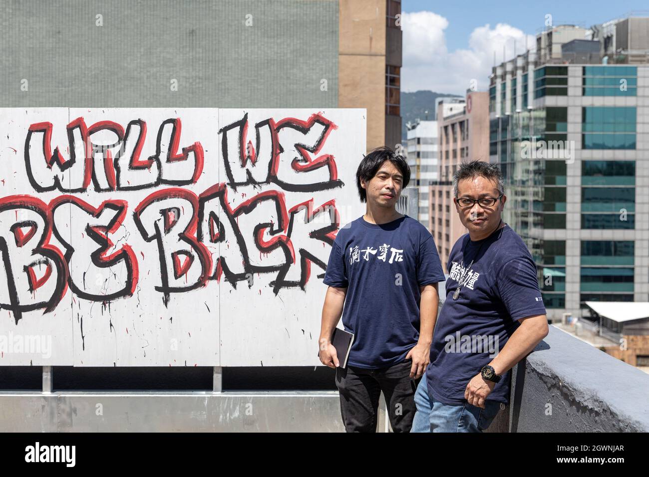 Hong Kong, Hong Kong. 25th Sep, 2021. HKCTU Chairman Joe Wong Nai-yuen (R) and vice-chairman Leo Tang Kin-wah (L) pose for a photo with a background of a graffiti reading ''When will we be back'' after the press conference of the union's last exhibition, showcasing their 31 years of fighting for labor rights.Under the political repression, Hong Kong biggest opposition trade union, The Hong Kong Confederation of Trade Unions (HKCTU) has special meeting on October 4 and passed the voting of disbandment as 57 votes agree, 8 oppose and 2 blank, ending its 31 years of service since 1990, follo Stock Photo