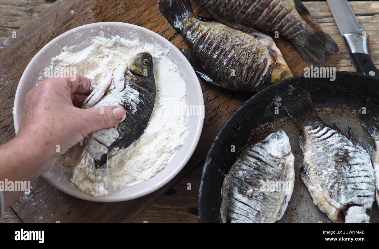 The Process Of Frying River Fish Crucian Carp In A Black Frying Pan