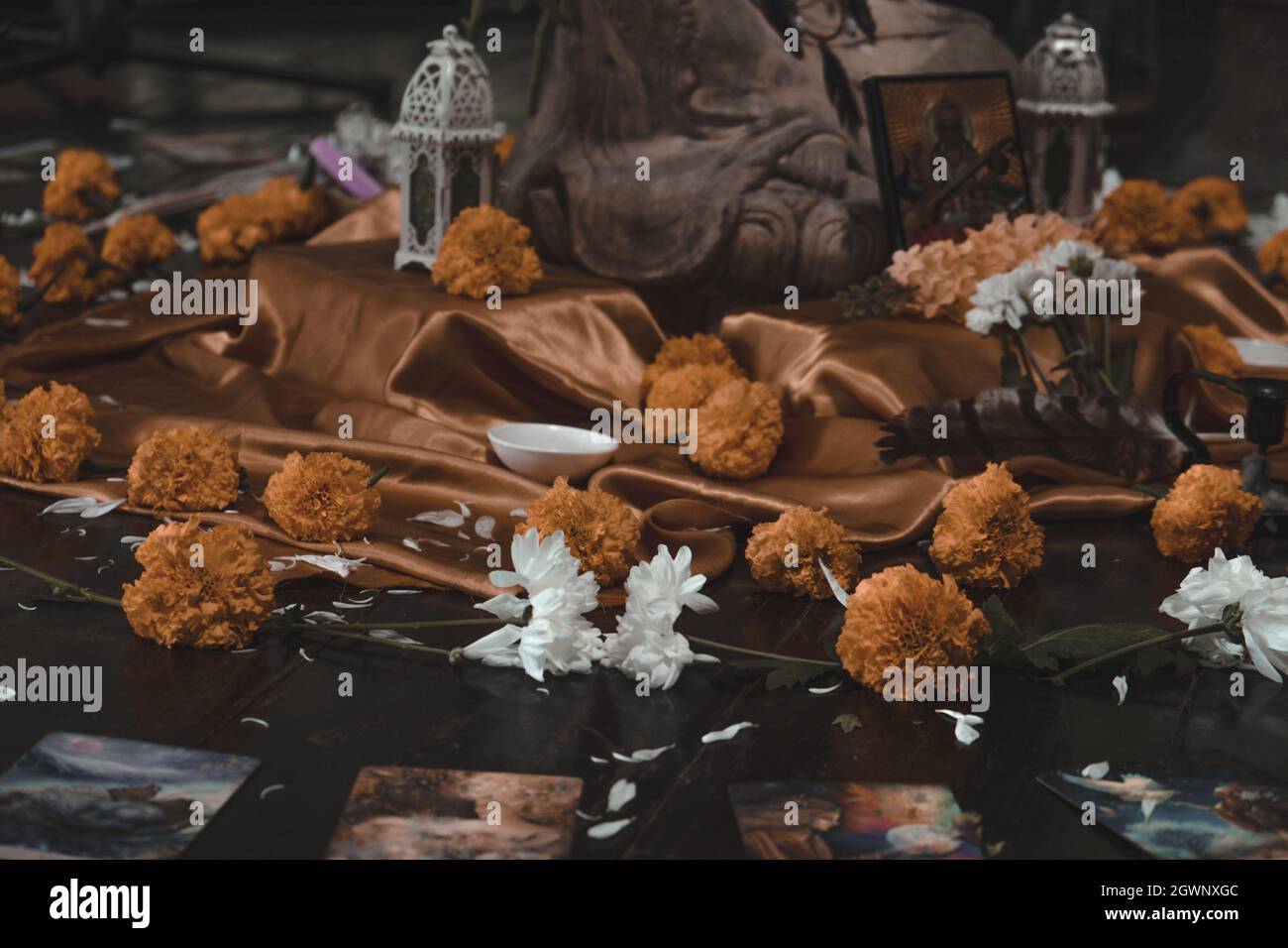 A closeup of flowers and religious icons on the ground during a ritual ...