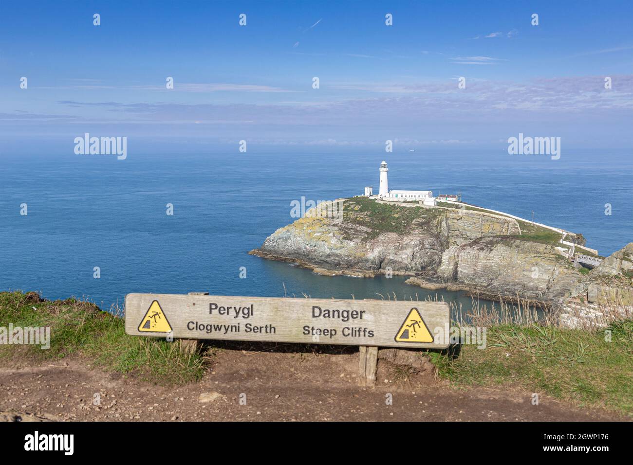 Holy Island, Wales: South Stack lighthouse (Ynys lawd) off the northwest coast of Anglesey. Warning sign on cliff edge. Stock Photo