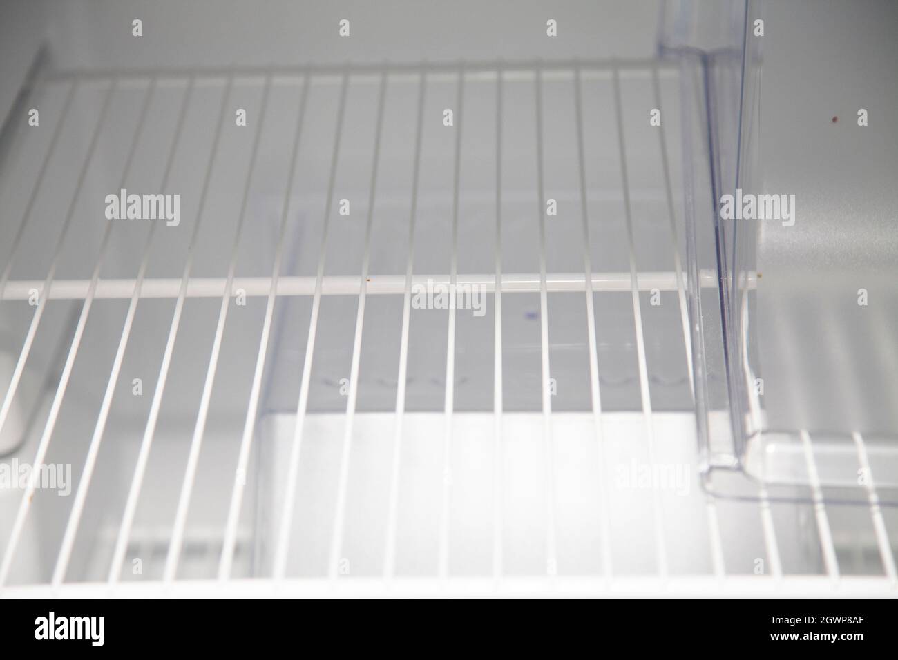 Empty shelf inside a clean, empty, white refrigerator Stock Photo