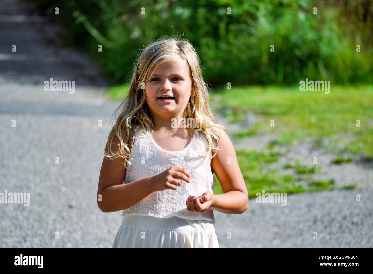 Portrait Of A Smiling Girl Standing Outdoors Stock Photo