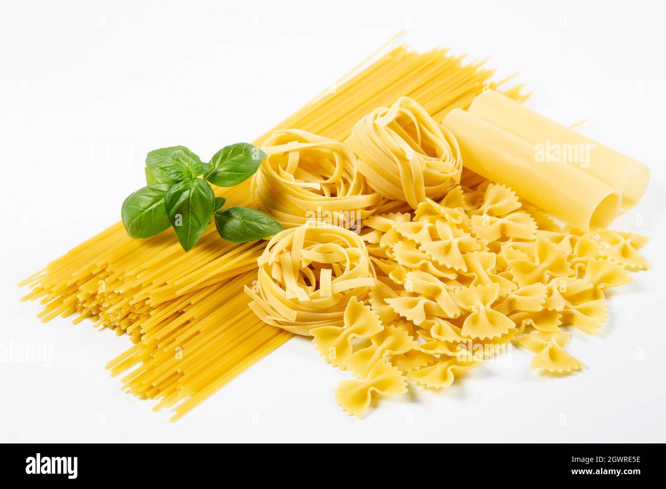 Various pasta with basil on white background Stock Photo