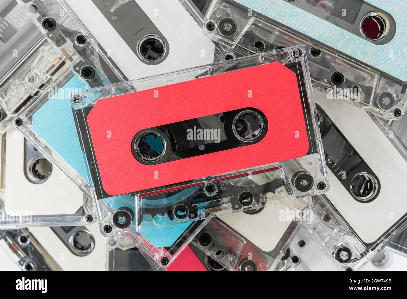 Pile of vintage audio cassette recording tapes with red tape on top. Stock Photo