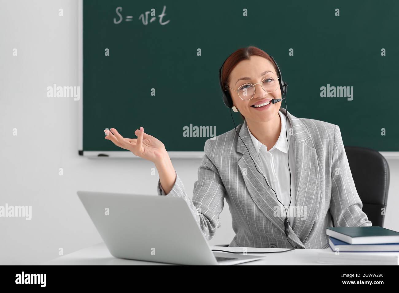 Teacher conducting lesson online in classroom Stock Photo - Alamy