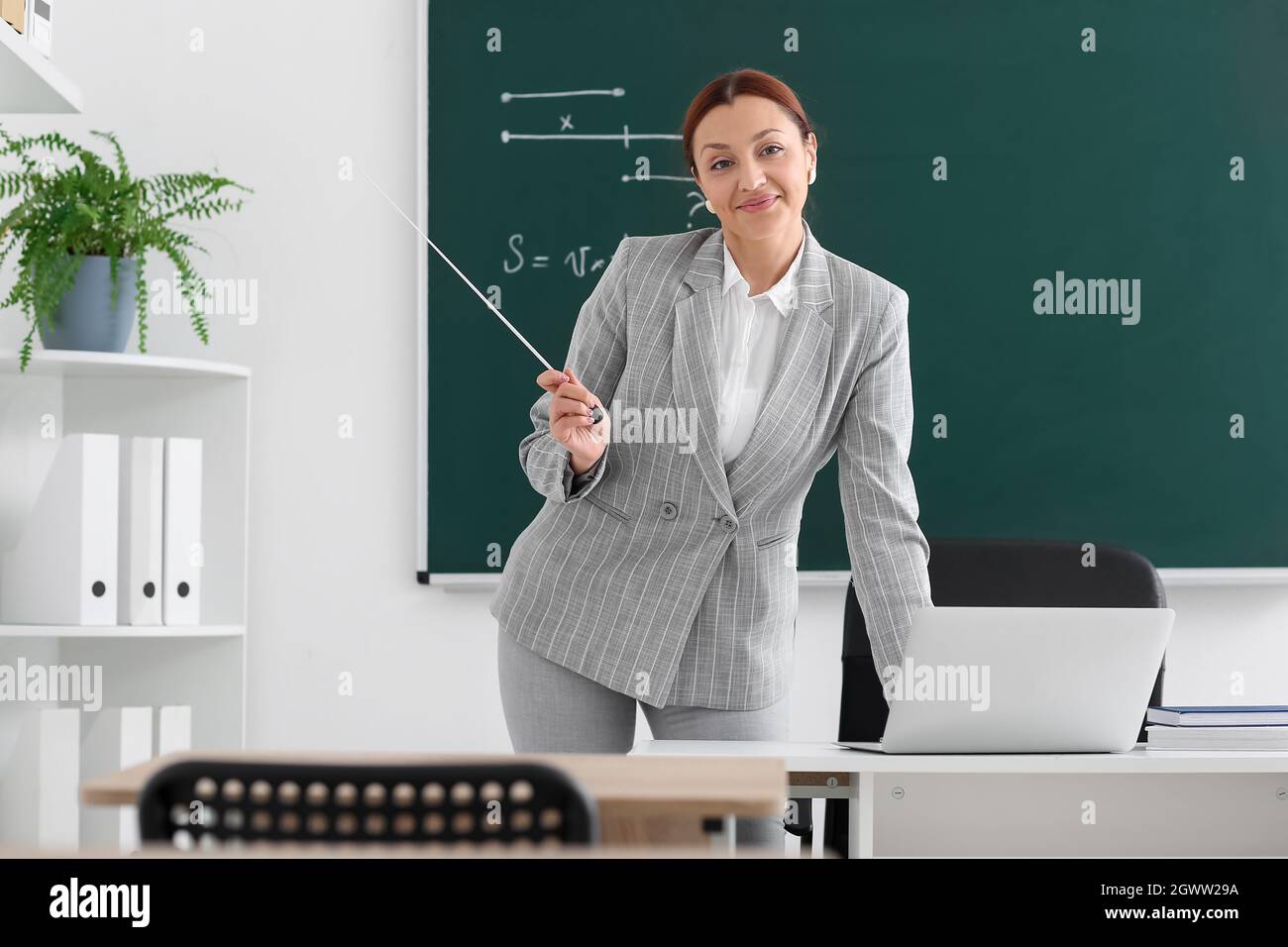 Teacher conducting lesson online in classroom Stock Photo - Alamy