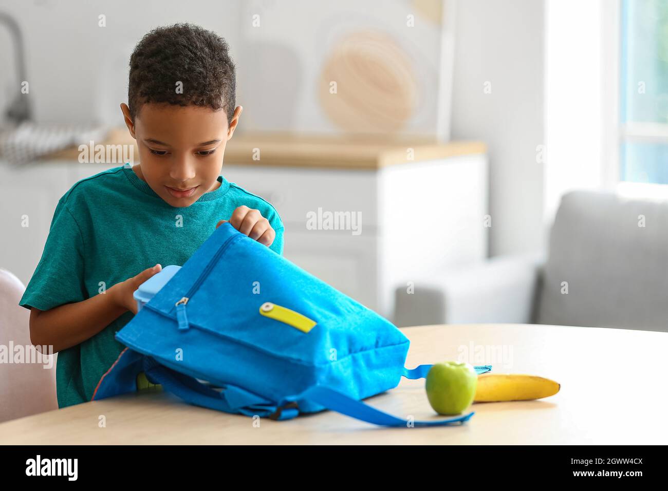 Cute little boy putting his school lunch in bag Stock Photo