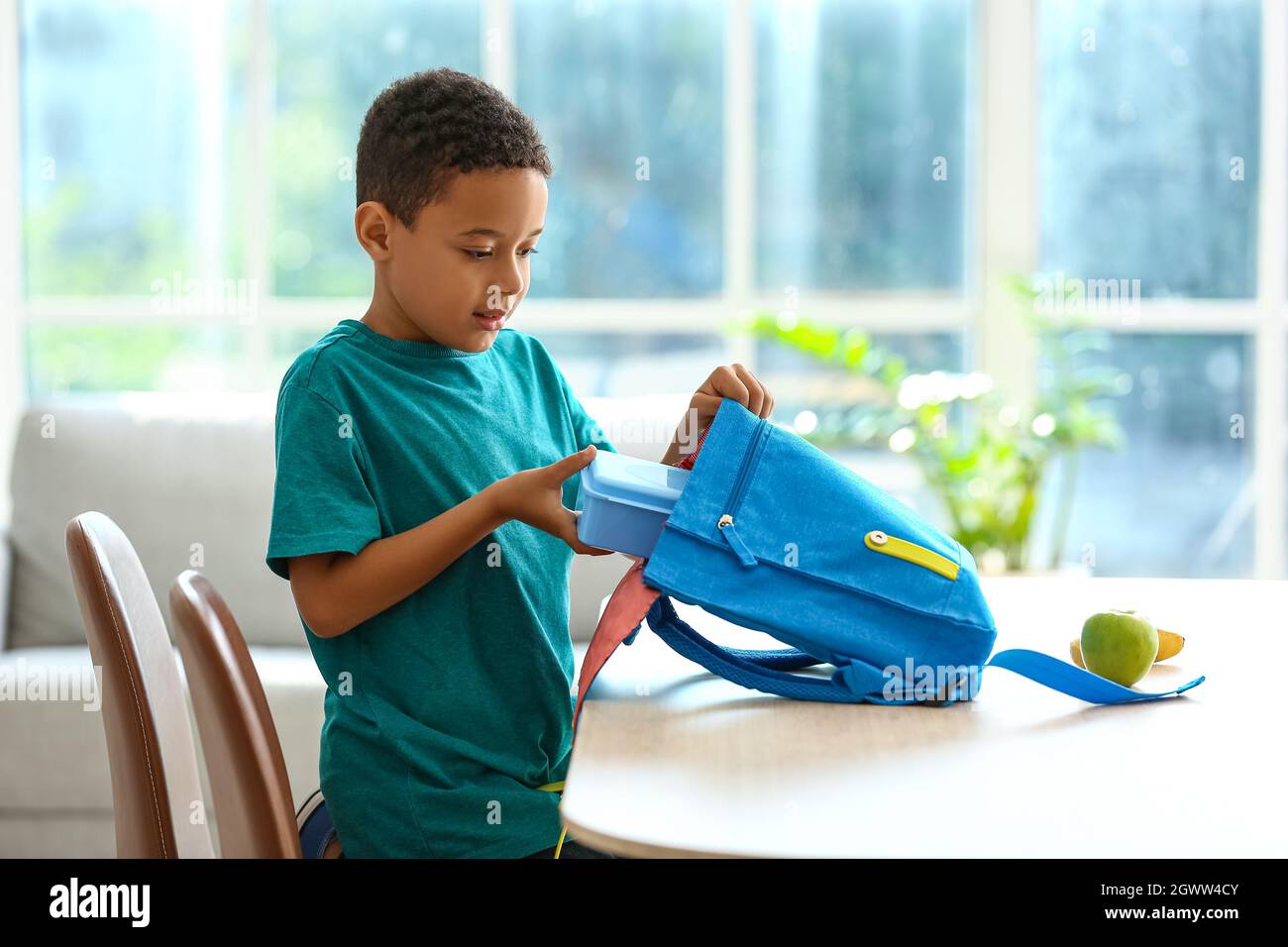 Cute little boy putting his school lunch in bag Stock Photo