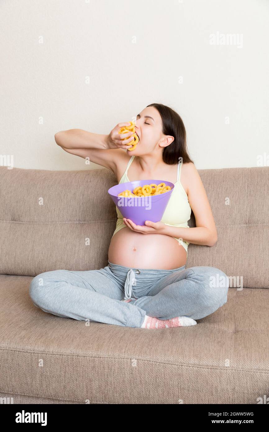 Pregnant woman eating meal chips hires stock photography and images