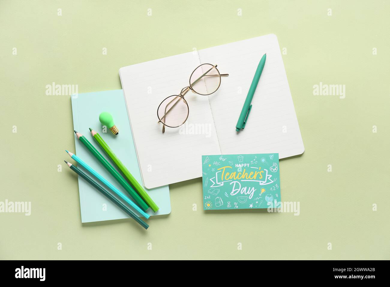 Teacher's Day concept. School supplies and greeting card on pink